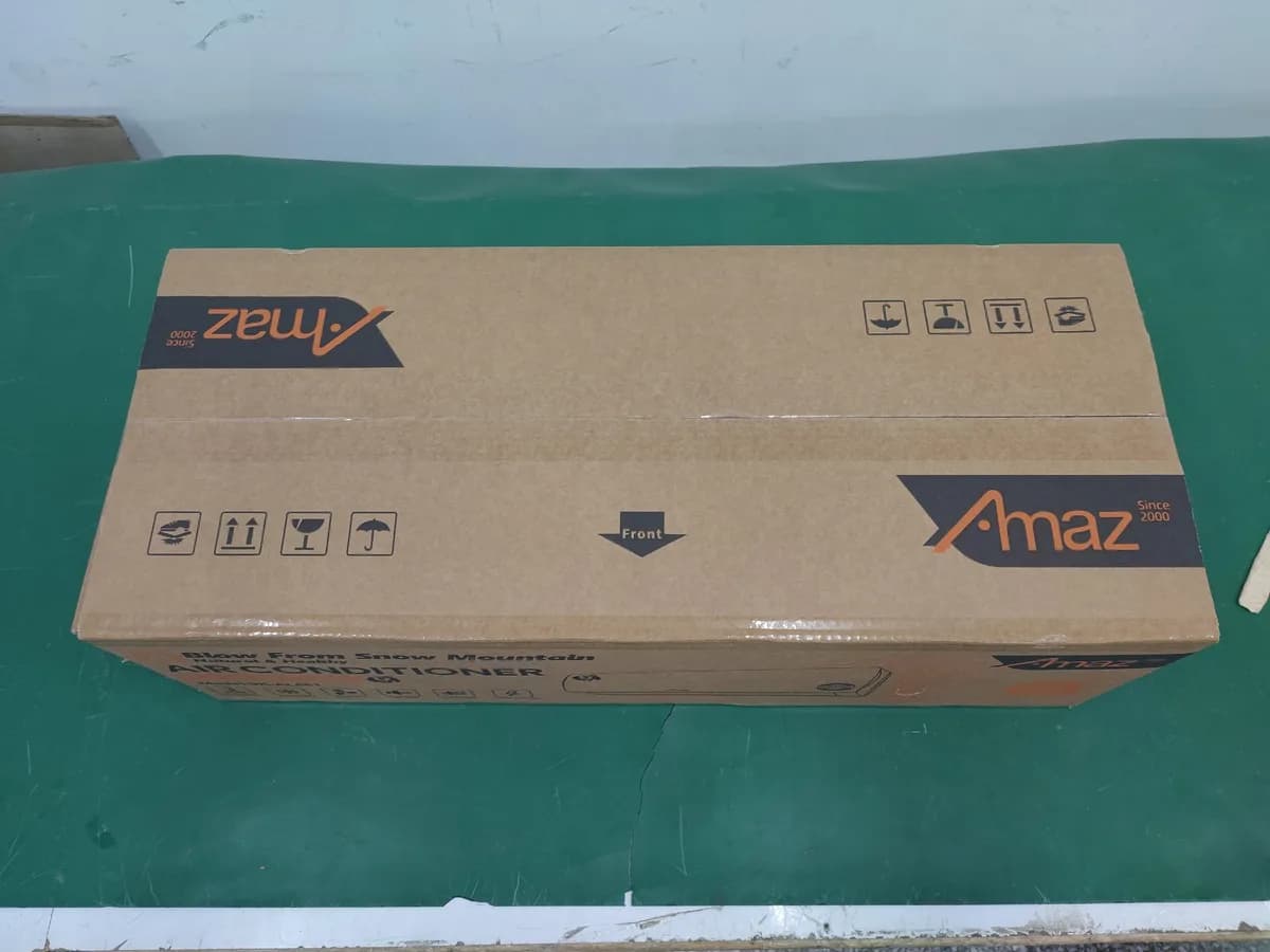 Caja de aire acondicionado AMAZ con cinta y símbolos de manipulación