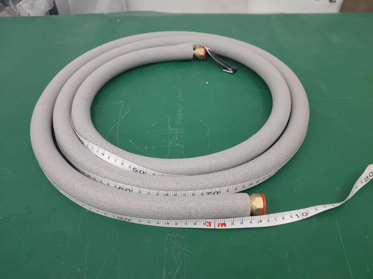 Tubería aislada de instalación junto a una cinta métrica